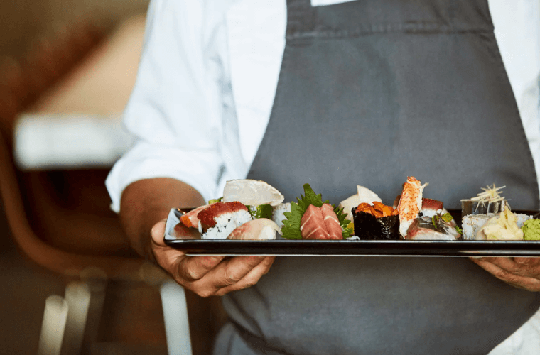 a chef holding a plate of food