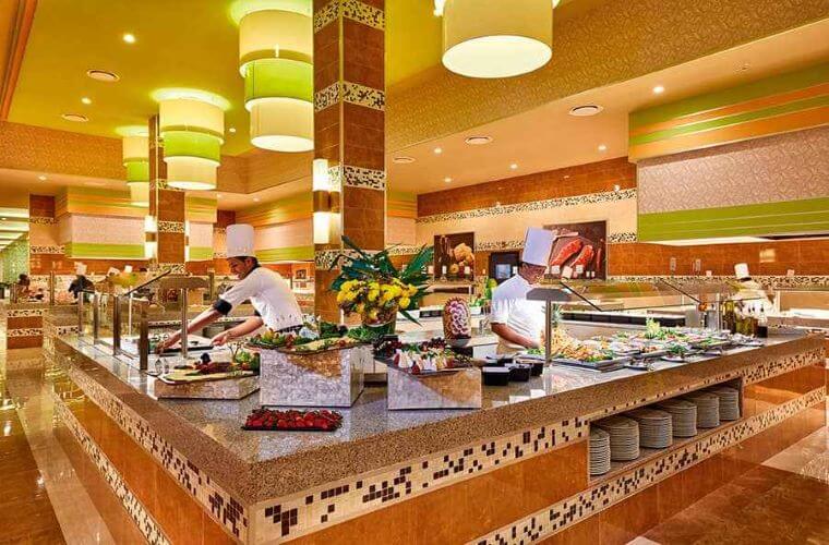 interior of a restaurant at Riu Palace Costa Mujeres with servers behind a counter 