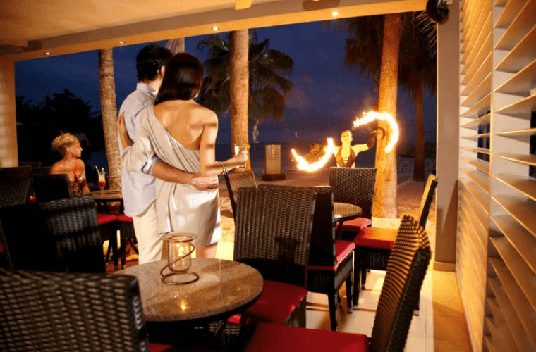 a couple watching a fire show on the beach 