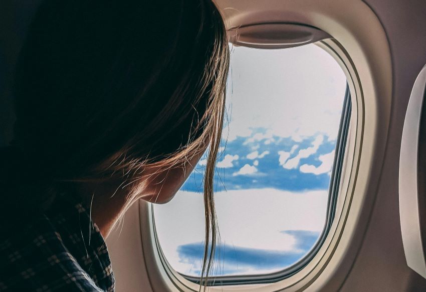 woman staring out of airplane window