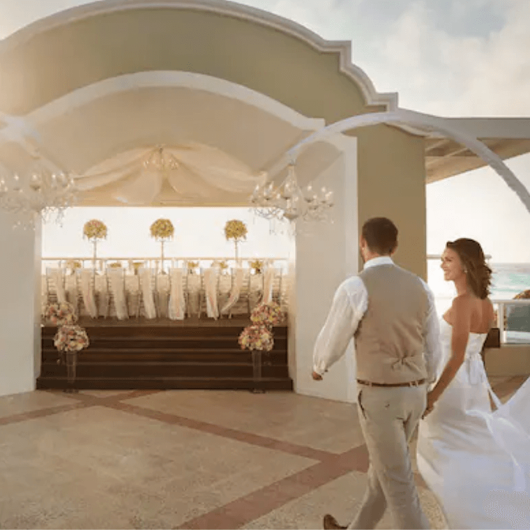 a bride and groom walking to the oceanfront wedding gazebo at Wyndham Alltra Cancun