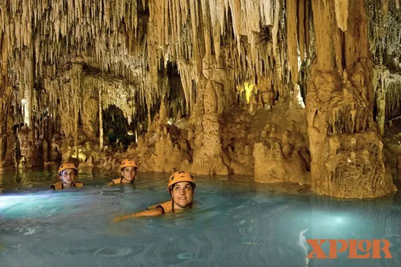 Girl swimming in a cave at Xplor Park, Riviera Maya, Mexico